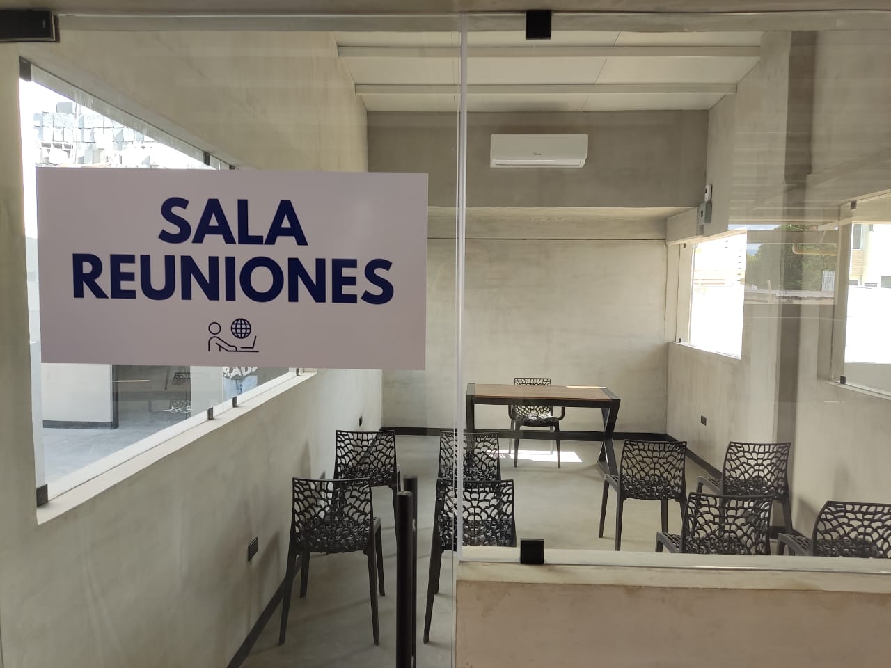 Sala de Reuniones WORKLAB vista a través de puerta de vidrio con cartel